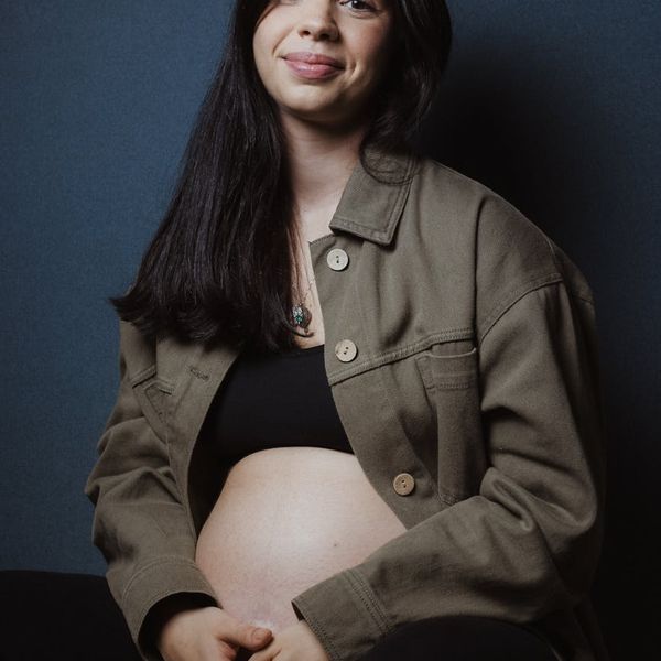 A close-up of a pregnant woman meditating with a peaceful expression.