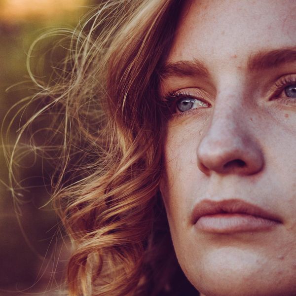 Profile of a woman with eyes closed, focusing on her breath.